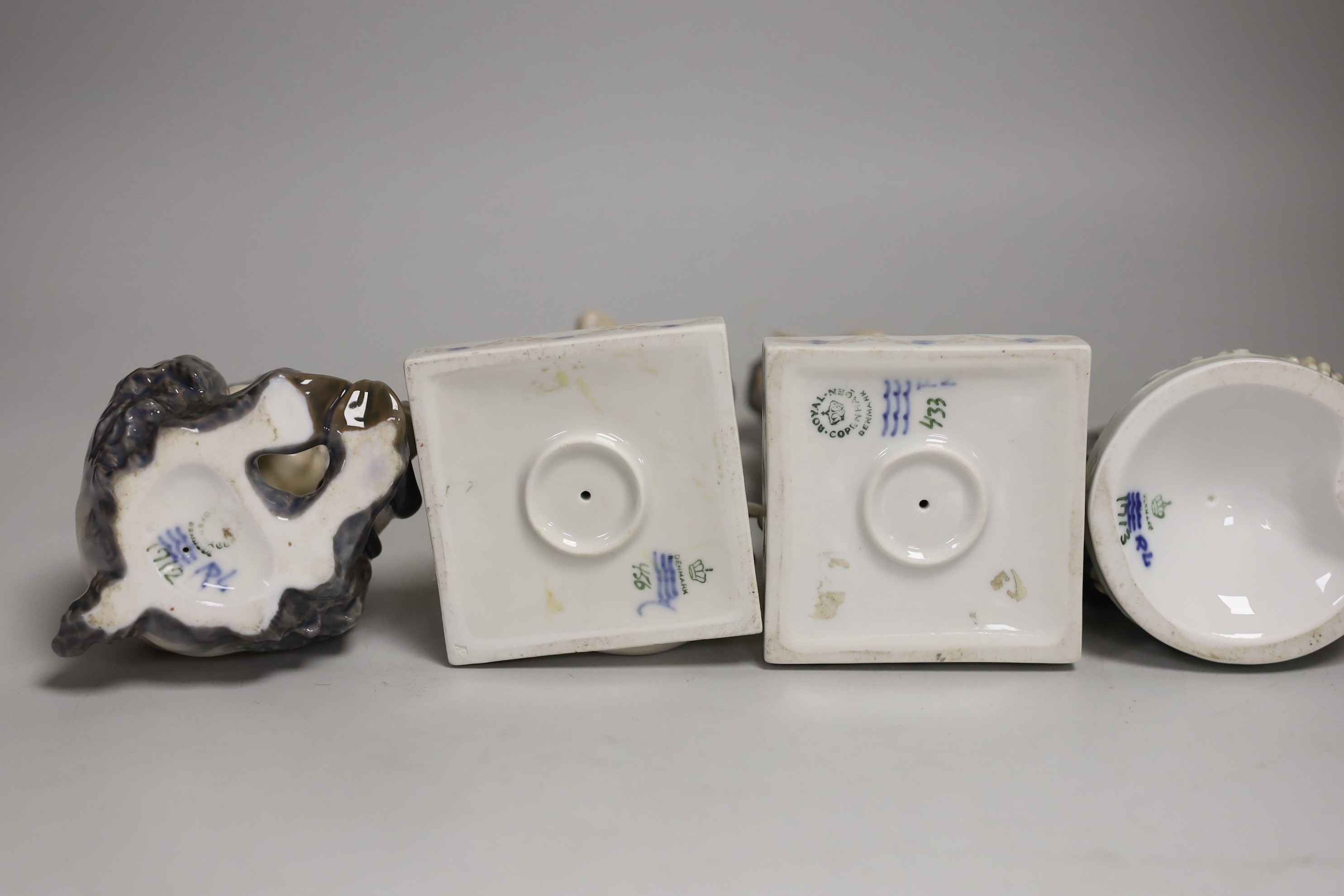 Four Royal Copenhagen models of Fauns, two playing musical instruments, one with a snake, the other with a frog. Tallest 21cm
